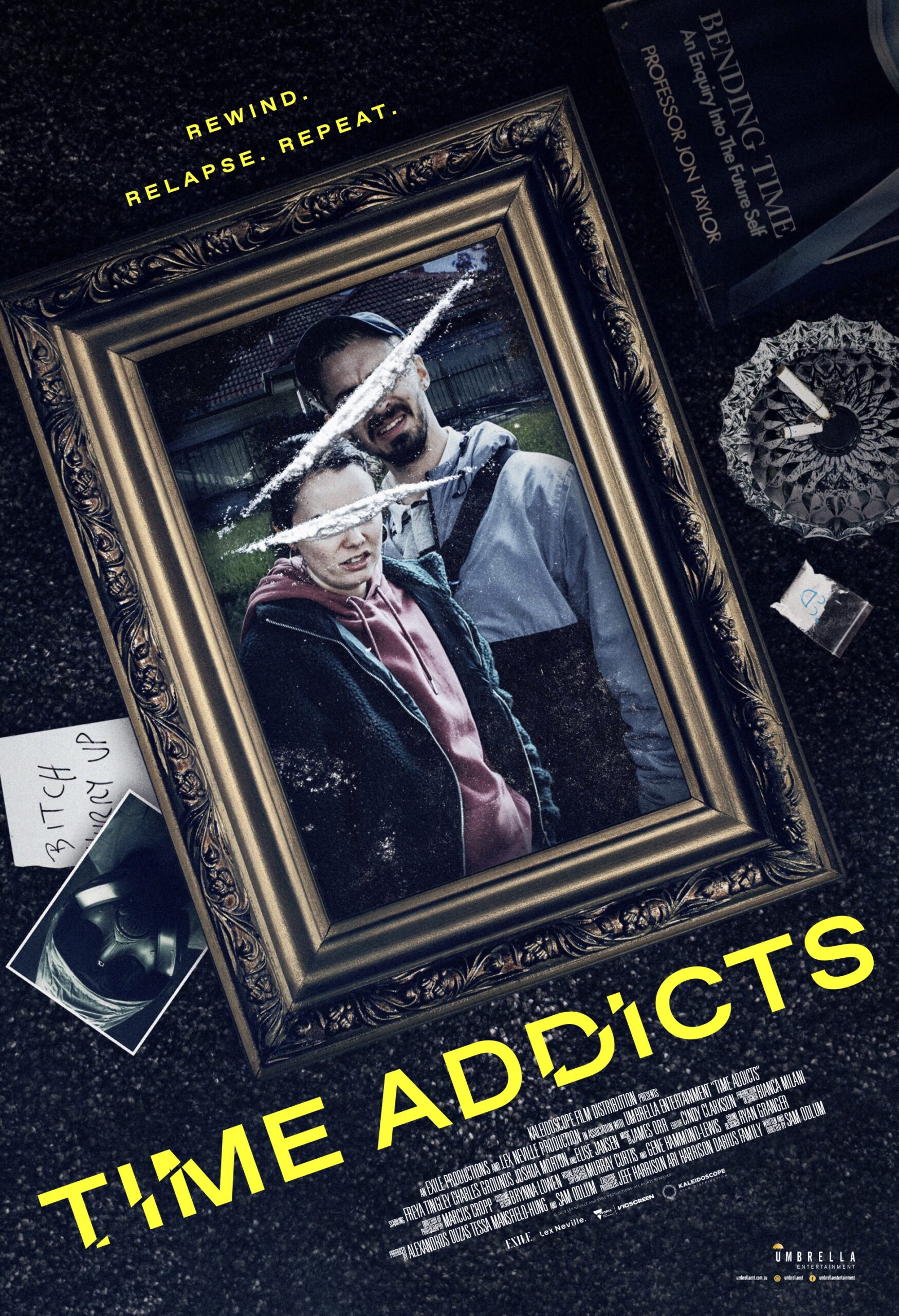 This movie poster for the film Time Addicts features a gold-framed photograph lying on a dark, textured surface. Inside the frame, a man and a woman are pictured outdoors. Two thick lines of white powder are laid across the glass of the frame, directly over the eyes of the two people. The image includes several other elements scattered around the frame: A book titled "Bending Time" by Professor Jon Taylor. An ashtray containing cigarette butts. A small plastic baggie with blue markings. A handwritten note that says "BITCH HURRY UP." A polaroid photo showing someone wearing a gas mask. The title TIME ADDICTS is written in large, bold yellow letters at the bottom, with small segments of the letters shifted to create a "glitch" or "time-slip" effect. The tagline at the top reads: "REWIND. RELAPSE. REPEAT."